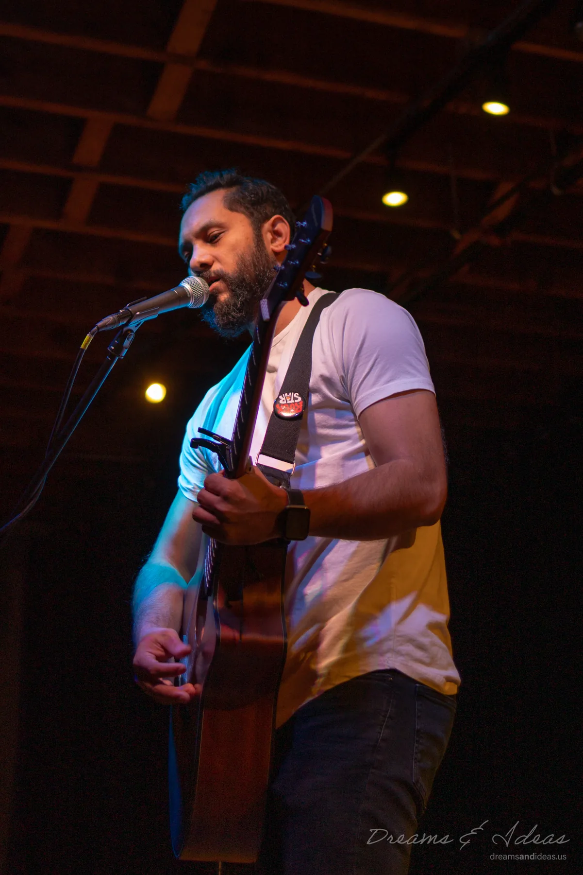 Saurav MP singing and playing guitar at a concert